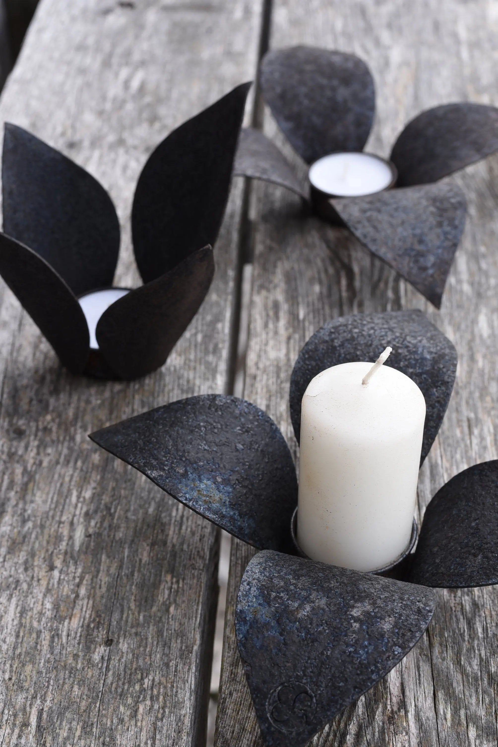 ljuslykta värmeljus i svärtad metall.